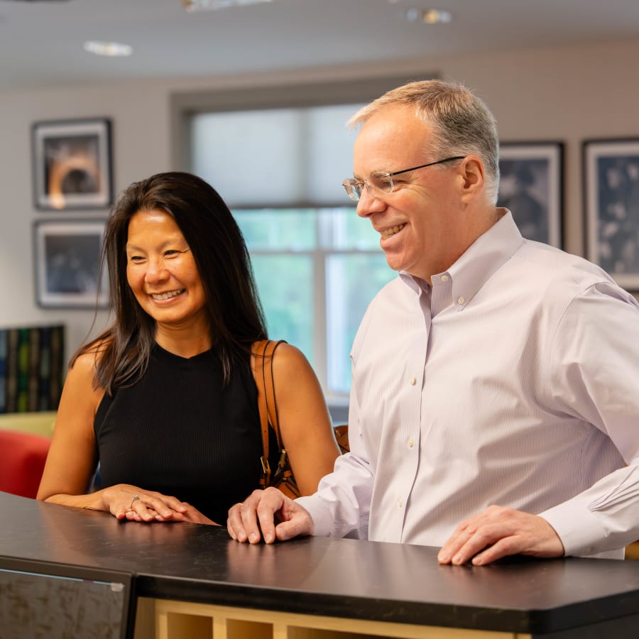 Two adult patients wait at the reception desk at Sturbridge Orthodontics.