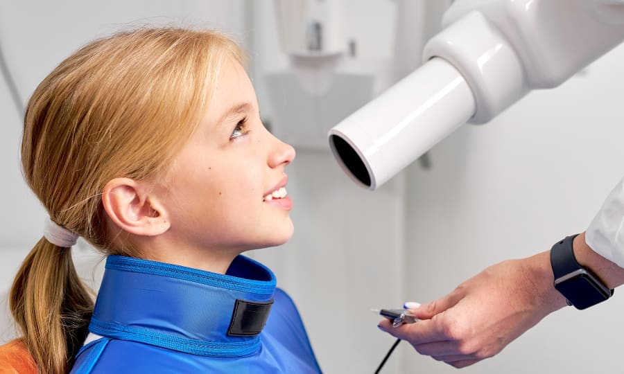 A dentist holds an X-ray up to the light for a better look.
